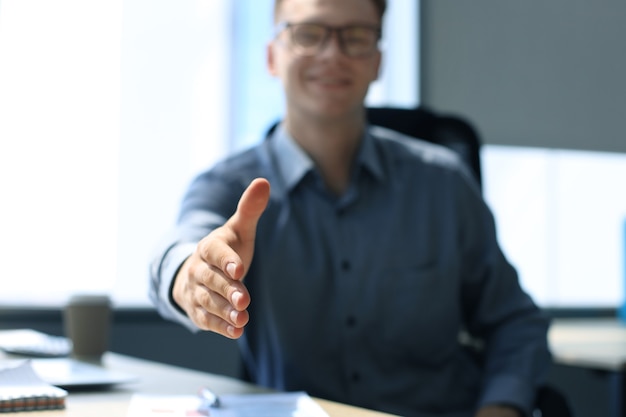 Uomo d'affari con una mano aperta pronta a sigillare un accordo in ufficio.