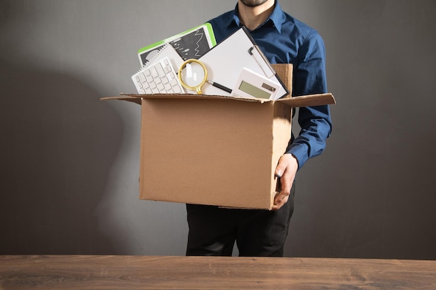 Uomo d'affari con una scatola di cartone e oggetti aziendali Perdita di posti di lavoro Disoccupazione