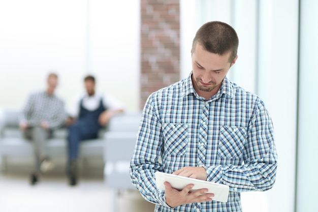 uomo d'affari con una tavoletta digitale in piedi in ufficio. persone e tecnologia