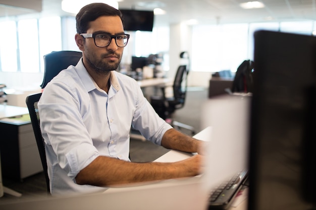 Uomo d'affari concentrato che lavora in ufficio