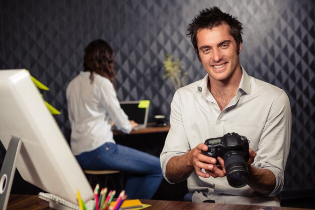 Uomo d'affari creativo che esamina immagine sulla macchina fotografica