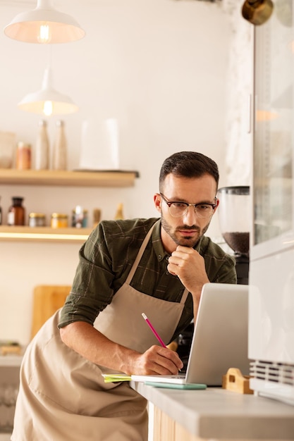 Uomo d'affari dagli occhi scuri che si sente occupato mentre ordina il caffè online