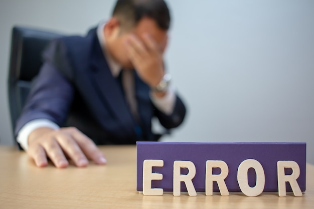 Uomo d&#39;affari depresso stanco sul posto di lavoro frustrato da fallimento aziendale.