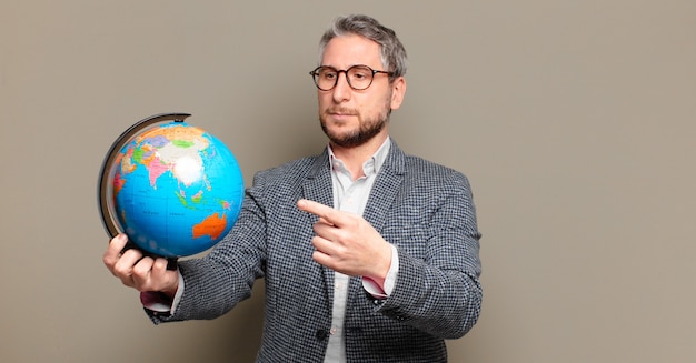 Uomo d'affari di mezza età con una mappa del globo del mondo