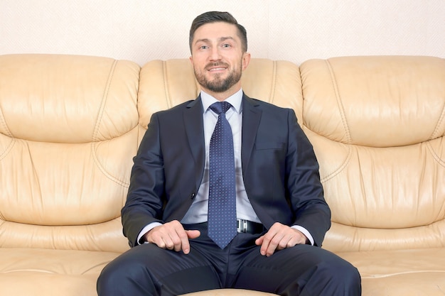 Uomo d'affari di successo seduto su un divano in pelle