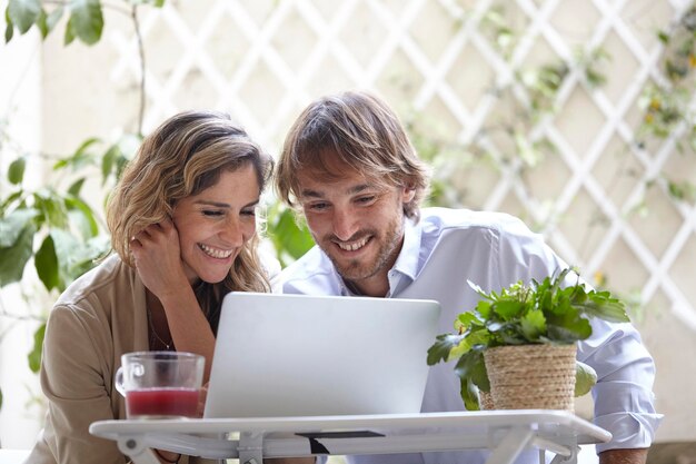 Uomo d'affari e donna che lavorano insieme al portatile all'aperto