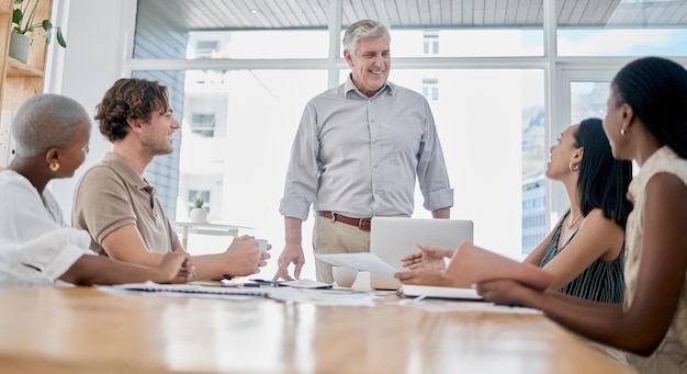 Uomo d'affari e team con riunione del leader o brainstorming in ufficio Impiegato o amministratore delegato di lavoro di squadra con progetto di gruppo del personale o condivisione di idee per la leadership collaborativa o l'innovazione sul posto di lavoro