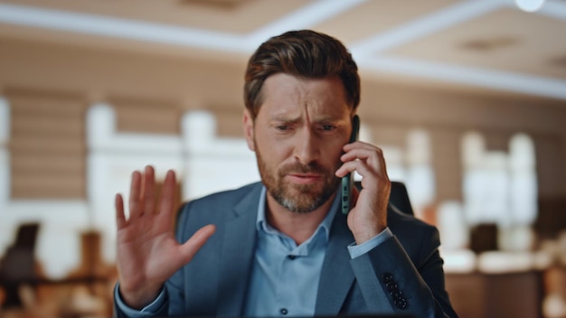 Uomo d'affari emotivo che parla al telefono al gabinetto close-up manager che gesticola con le mani
