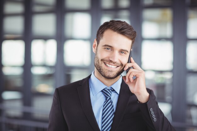 Uomo d'affari felice che parla sul telefono cellulare