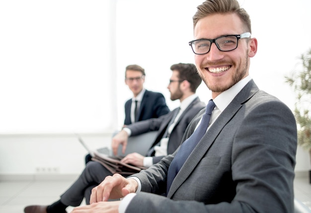 Uomo d'affari felice che si siede nella sala d'attesa dell'ufficio