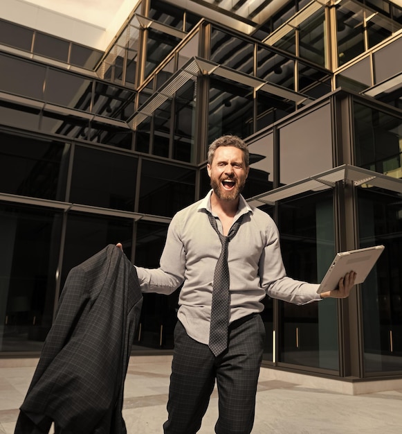 Uomo d'affari felice di successo che grida celebrando la felicità all'aperto di successo aziendale