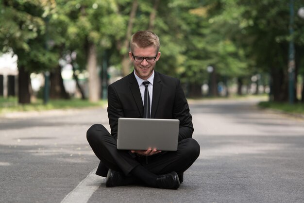 Uomo d'affari felice utilizzando Tablet Pc fuori su asfalto