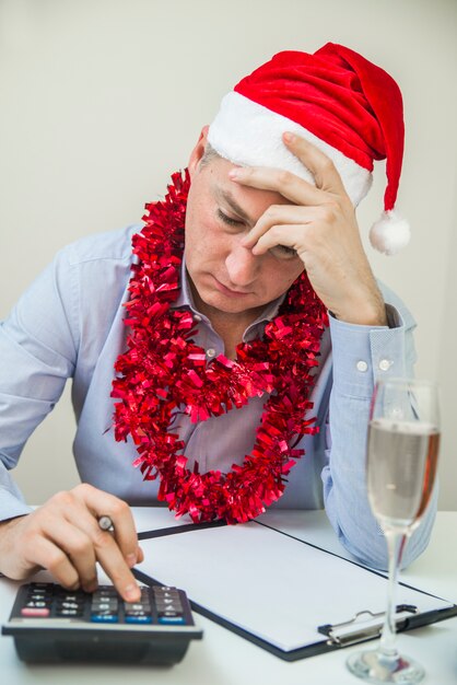 Uomo d&#39;affari festeggia Buon Natale e felice anno nuovo indossano cappello di Santa