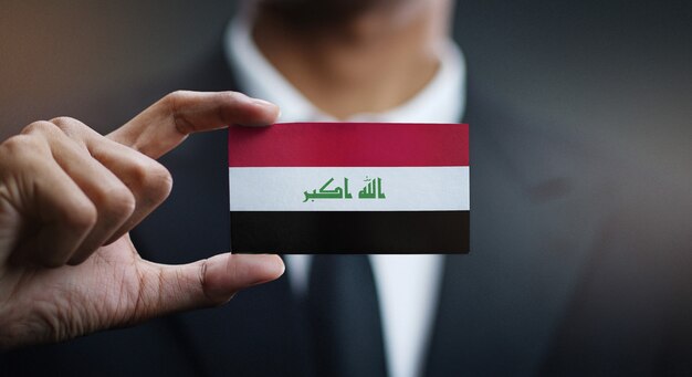 Uomo d&#39;affari Holding Card della bandiera dell&#39;Iraq