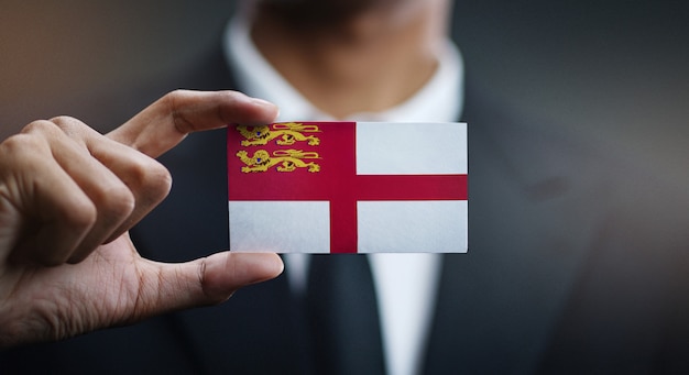 Uomo d&#39;affari Holding Card of Sark Flag