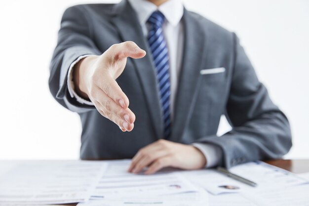 Uomo d'affari in abito elegante a una riunione di lavoro che dà la mano per salutare in ufficio