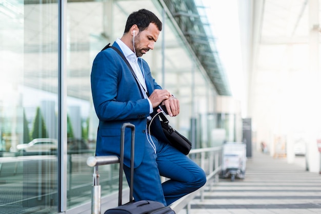 Uomo d'affari in aeroporto guardando in guardia