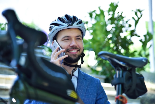 Uomo d'affari in casco seduto sulle scale e parlando sul cellulare