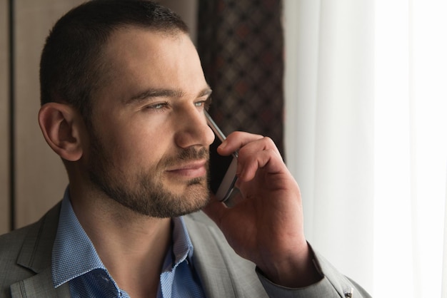 Uomo d'affari in soggiorno parlando al telefono