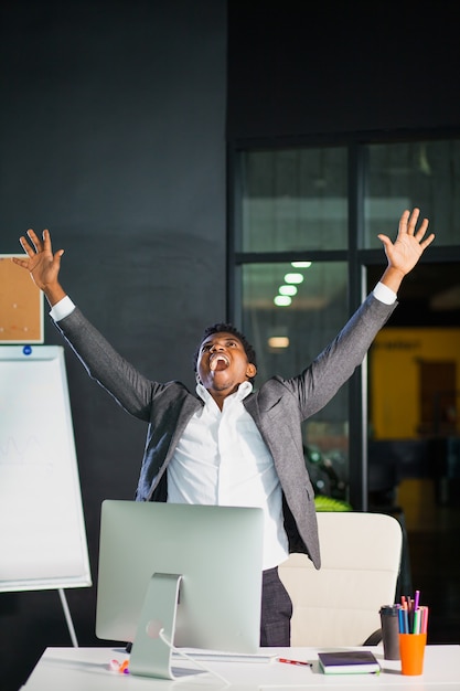 Uomo d'affari in ufficio, gesto di successo, obiettivo raggiunto, uomo felice