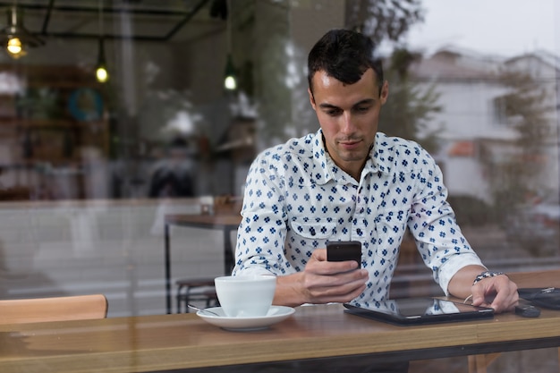 Uomo d'affari in un caffè parlando al telefono