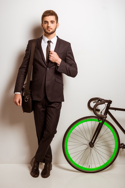 Uomo d'affari in un tailleur con una bicicletta.