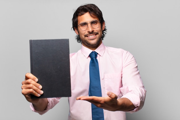 Uomo d'affari indiano bello adulto che tiene un libro