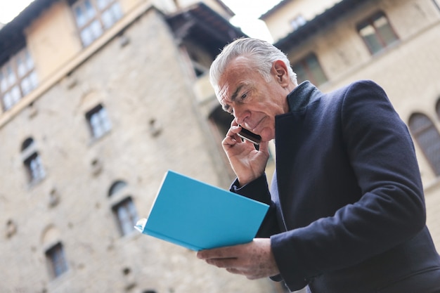 Uomo d&#39;affari maggiore che parla su uno smartphone