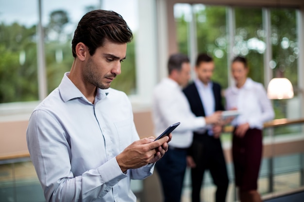 Uomo d'affari maschio che per mezzo del telefono cellulare