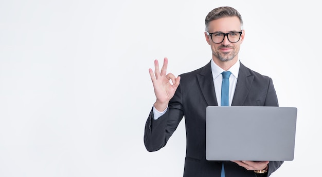 Uomo d'affari maturo che lavora al computer portatile isolato su priorità bassa bianca ok