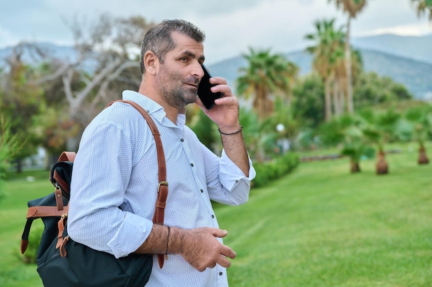 Uomo d'affari maturo che parla al telefono all'aperto