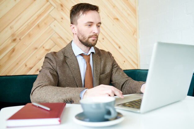 Uomo d'affari moderno che lavora in caffè