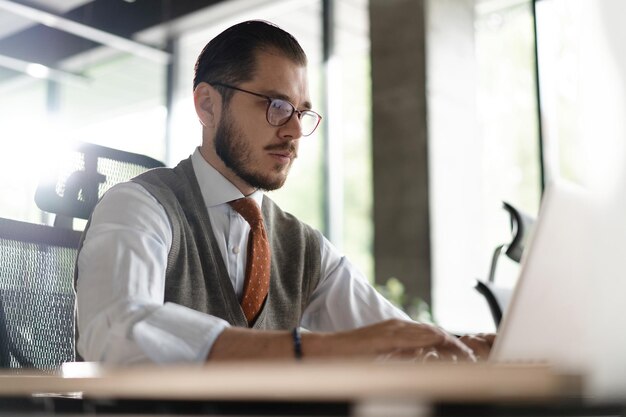 Uomo d'affari moderno dell'ufficio che lavora al computer Ritratto di ingegnere informatico IT di mezza età di successo che lavora al computer portatile