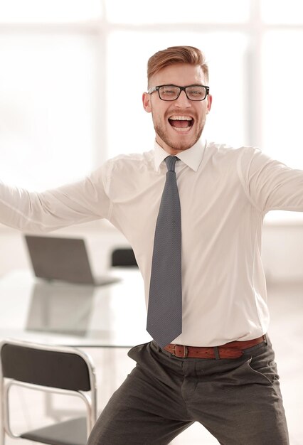 Uomo d'affari molto felice sul backgroundphoto dell'ufficio con lo spazio della copia