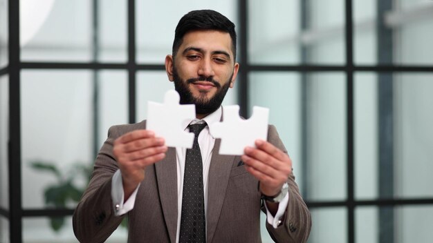 Uomo d'affari mostra puzzle bianco in mano concetto di strategia aziendale
