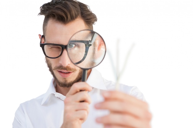 Uomo d&#39;affari nerd guardando attraverso la lente di ingrandimento