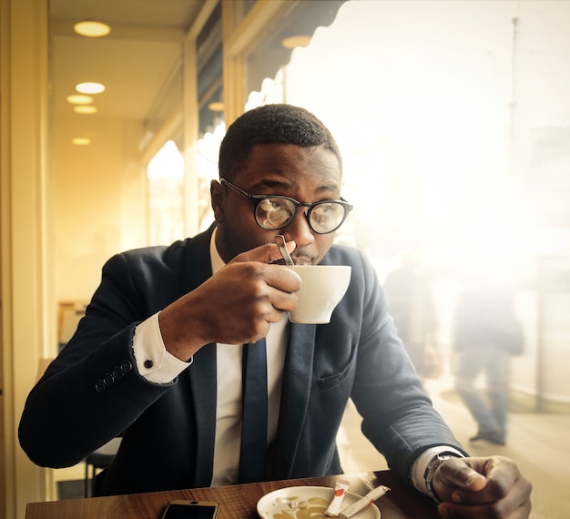 Uomo d&#39;affari nero che beve un caffè