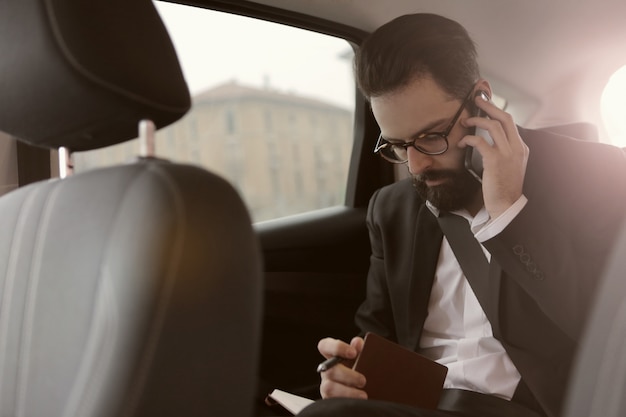 Uomo d&#39;affari parlando al telefono in auto