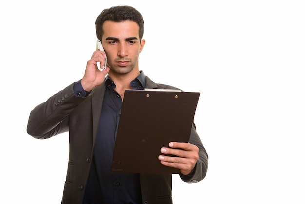Uomo d'affari persiano utilizzando il telefono e tenendo appunti