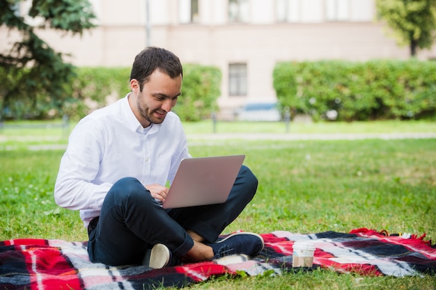 Uomo d'affari premuroso nel campo. Con laptop