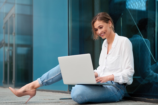 Uomo d'affari riuscito della donna della donna di affari all'aperto con il computer portatile delle cellule