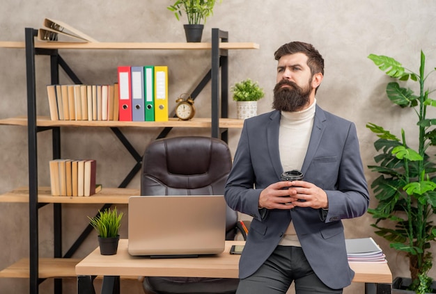 Uomo d'affari serio che pensa durante la pausa caffè in ufficio premuroso