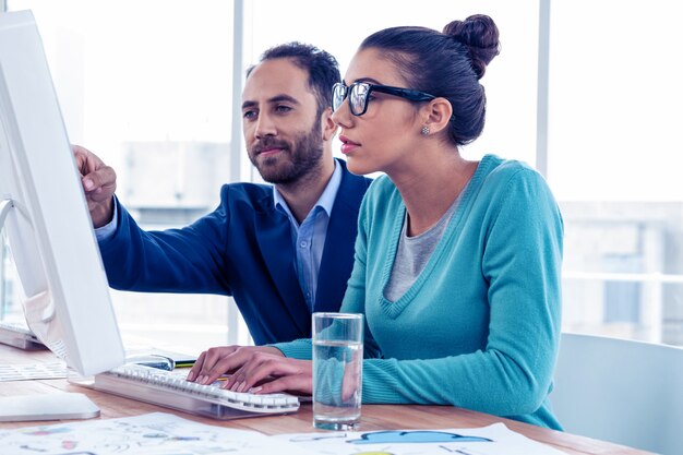 Uomo d&#39;affari serio e donna di affari che discutono sopra il computer all&#39;ufficio creativo