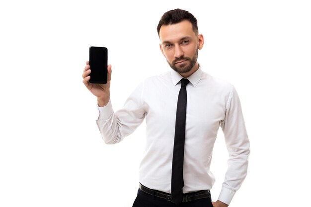 Uomo d'affari serio ed elegante di mezza età che mostra lo schermo dello smartphone su sfondo bianco