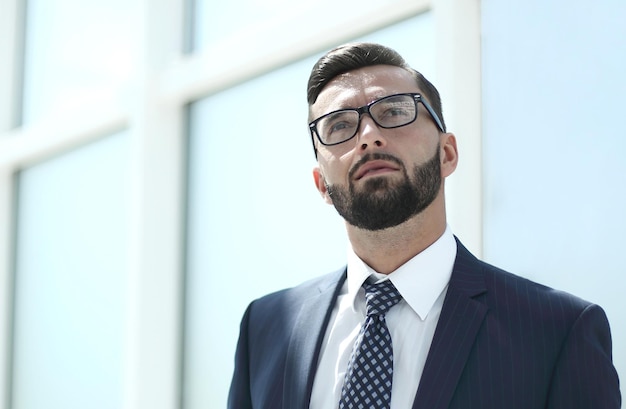 Uomo d'affari serio in piedi in un officephoto luminoso con spazio per la copia