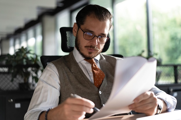 Uomo d'affari soddisfatto che legge documenti cartacei lettere che ricevono notizie piacevoli libero professionista guardando contratto con buona offerta