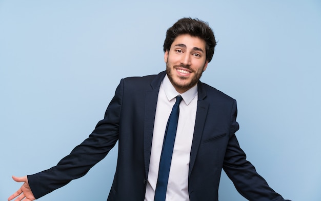 Uomo d&#39;affari sopra sorridere blu isolato della parete