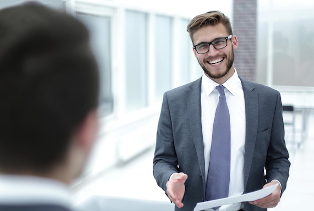 Uomo d'affari sorridente che cerca un concetto di stretta di mano di partnership