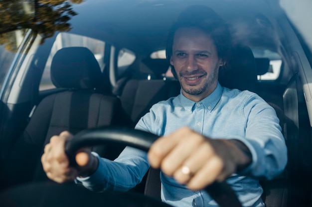 Uomo d'affari sorridente che guida un'auto