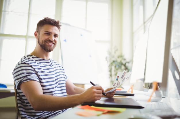 Uomo d'affari sorridente che lavora nell'ufficio creativo